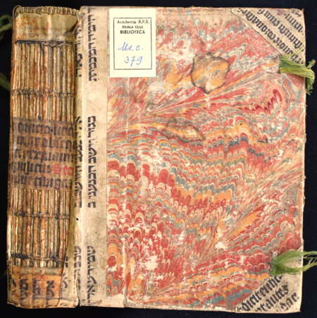 Nærbilde av historisk bok der deler av omslaget er gjenbruk av gamle boksider.